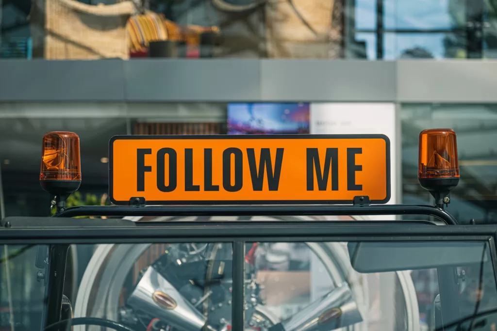"Follow Me" sign next to a siren