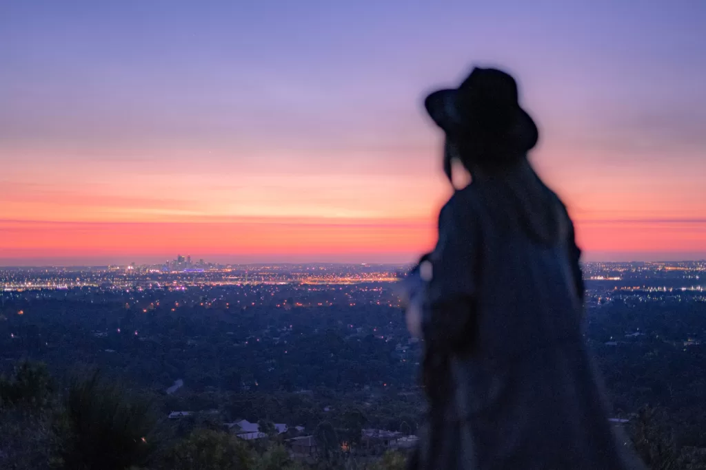 A spiritual woman standing at the top of the hill and contemplating